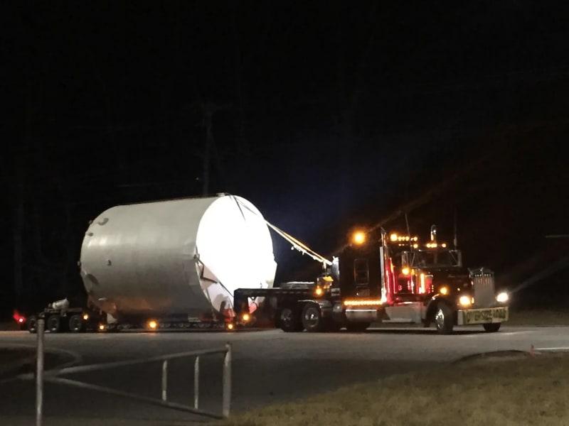 Another view of a white fiberglass tank on a truck at night